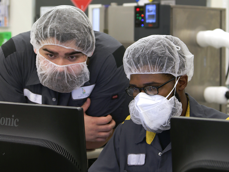 Picture of two employees working side by side at Red Mesa Science reviewing data on a computer screen