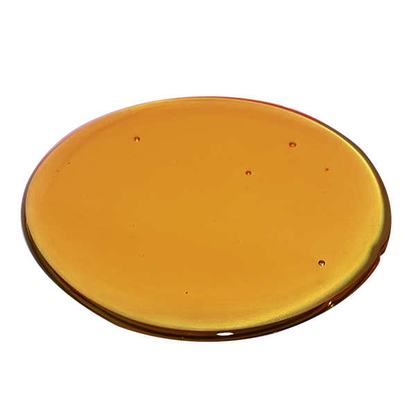 Image is of a droplet of Crystal Resistant Distillate to show its dark amber translucent flowable viscosity